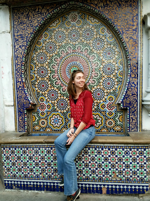 Kelsey Cochran '18 sits infront of a fountain